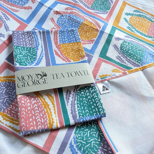 Colorful tea towels with a brand label on a white fabric background