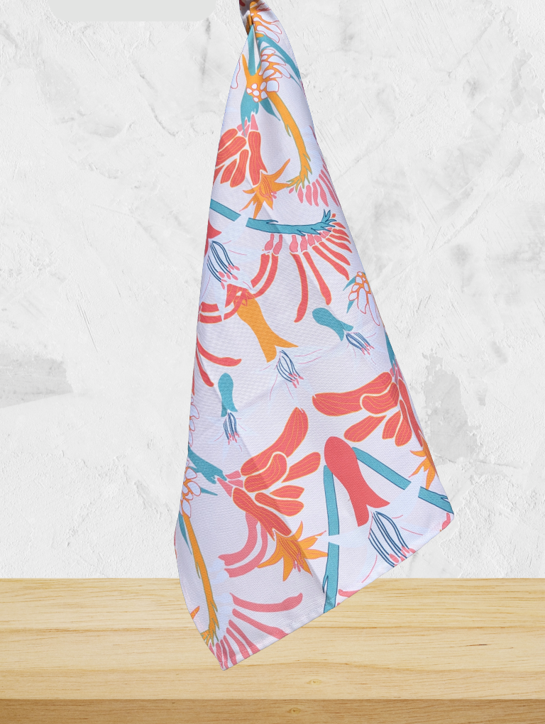 Colorful towel with floral pattern on a wooden surface and light gray background