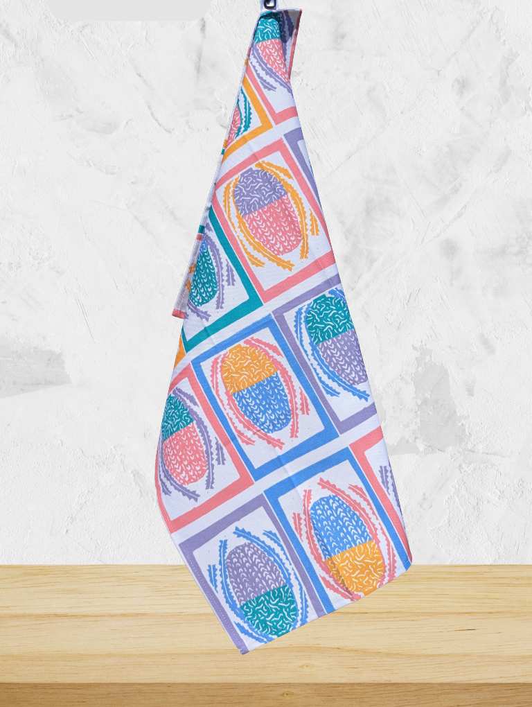 Colorful patterned towel hanging on a wooden surface with a white background