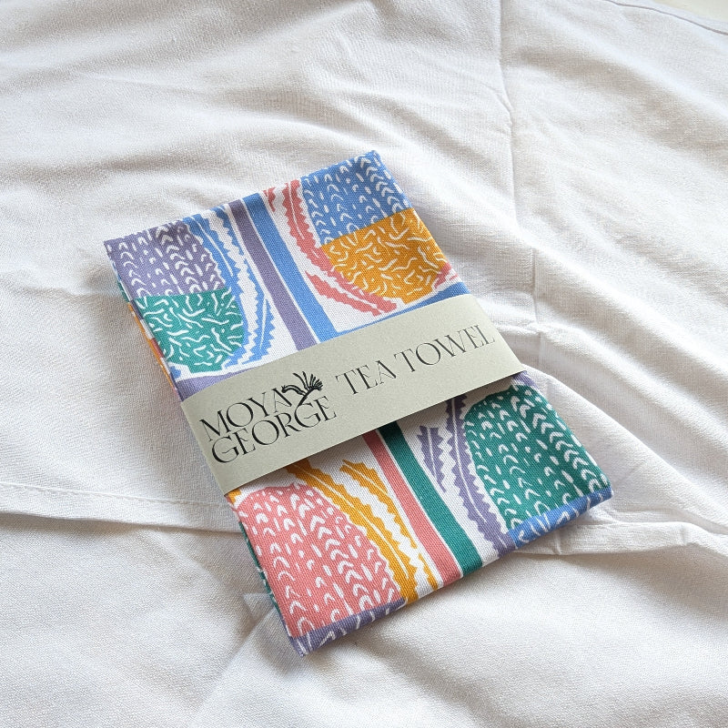 Colorful tea towel with a brand label on a white fabric background