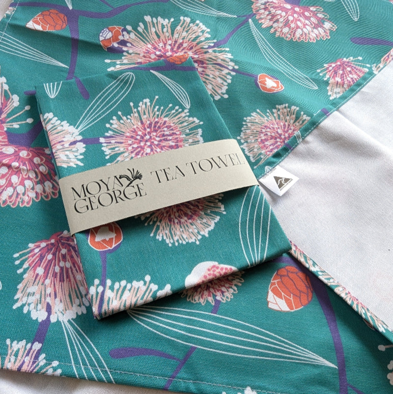 Teal floral tea towel with 'Moye George' branding on a white background