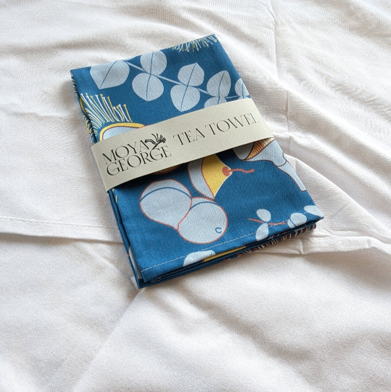 Tea towel with blue floral design on a white surface