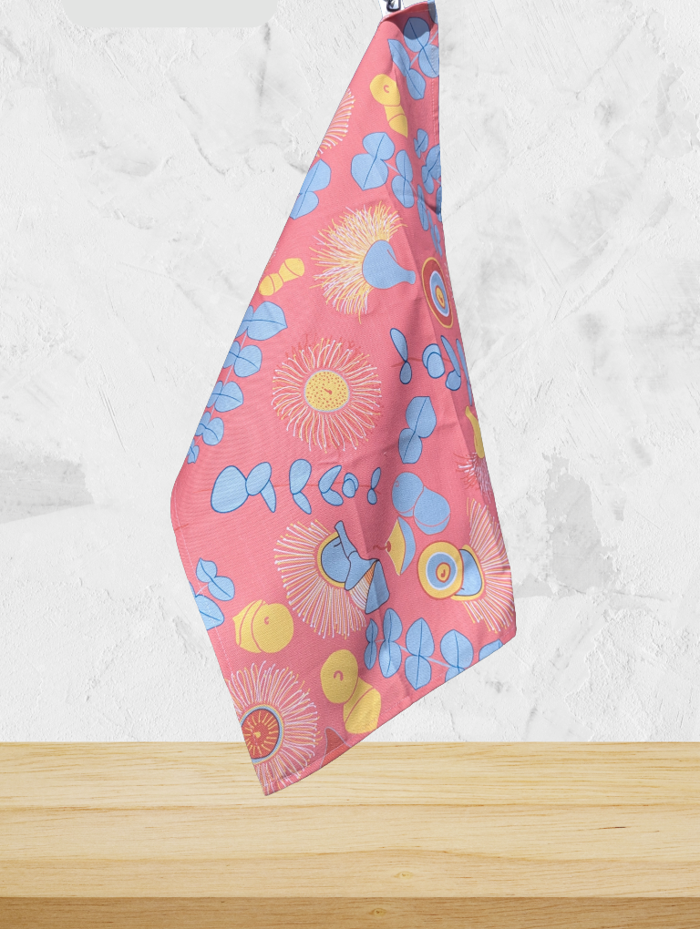 Colorful floral-patterned towel on a wooden surface with a white marble background