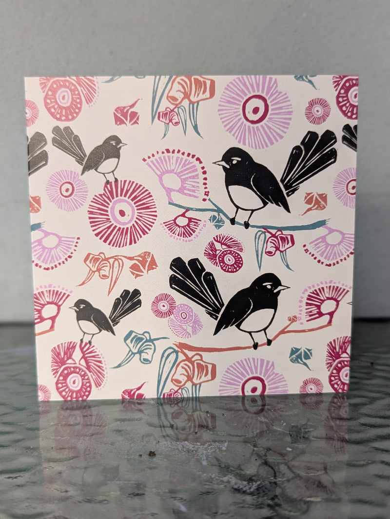 Card with black birds and colorful floral patterns on a gray background